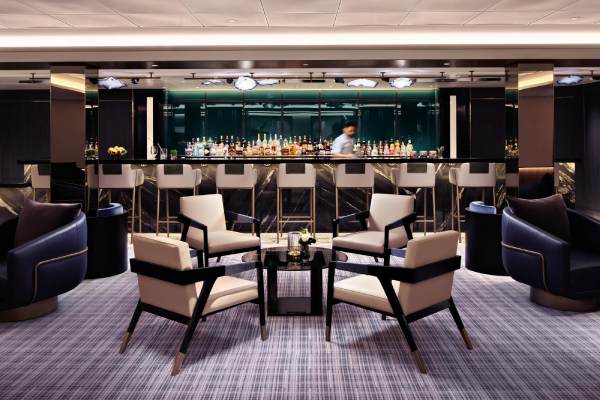 Bold blue hues that mirror the sea add a vibrant pop to the yacht's social hub, featuring stylish, comfortable furnishings and a library stocked with travel guides and bestsellers. By day, The Living Room Cafe offers elevated grab-and-go fare to fuel your adventures ashore; come sundown, The Living Room evolves into a lively piano bar.